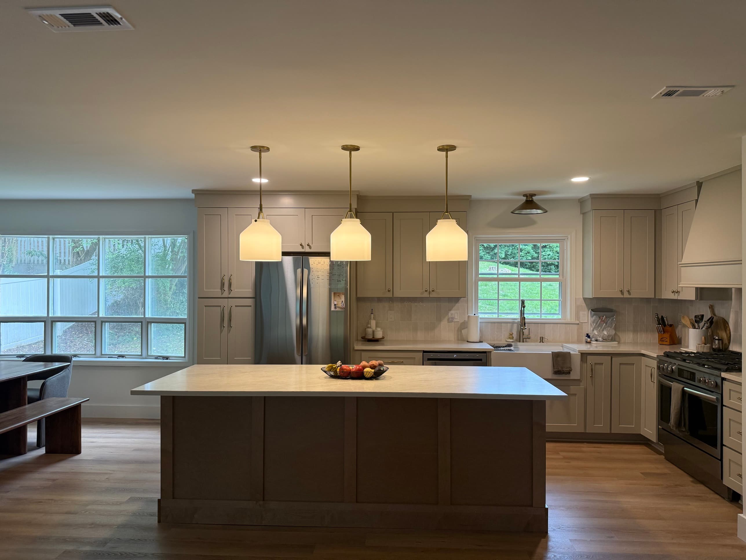 Luxury kitchen remodel with large island, custom pendant lighting, gray shaker cabinets, and quartz countertops in Charlotte, NC by Remodel CLT
