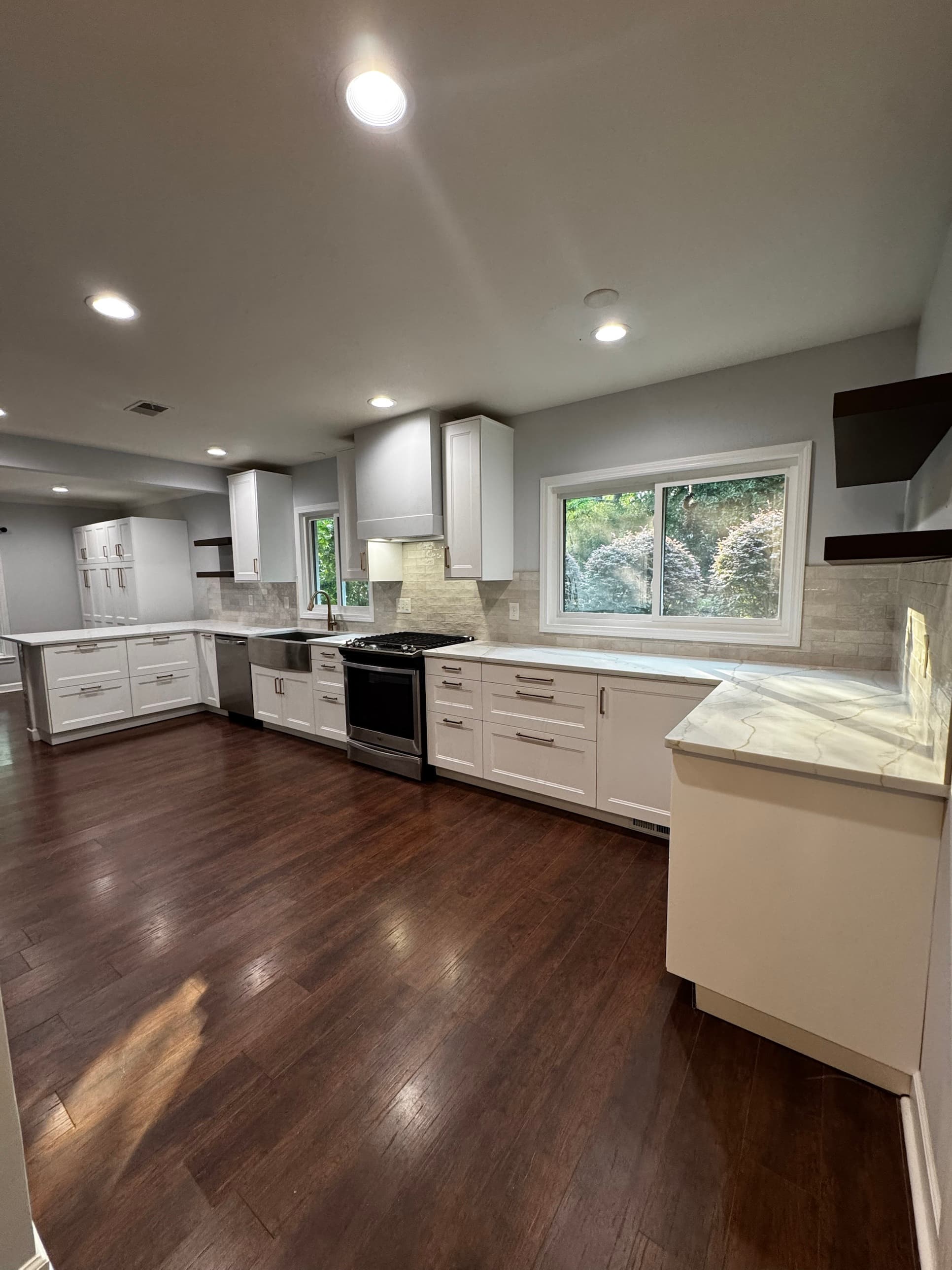 Kitchen remodel with white shaker cabinets, marble quartz countertops, and farmhouse sink in Charlotte, NC by Remodel CLT