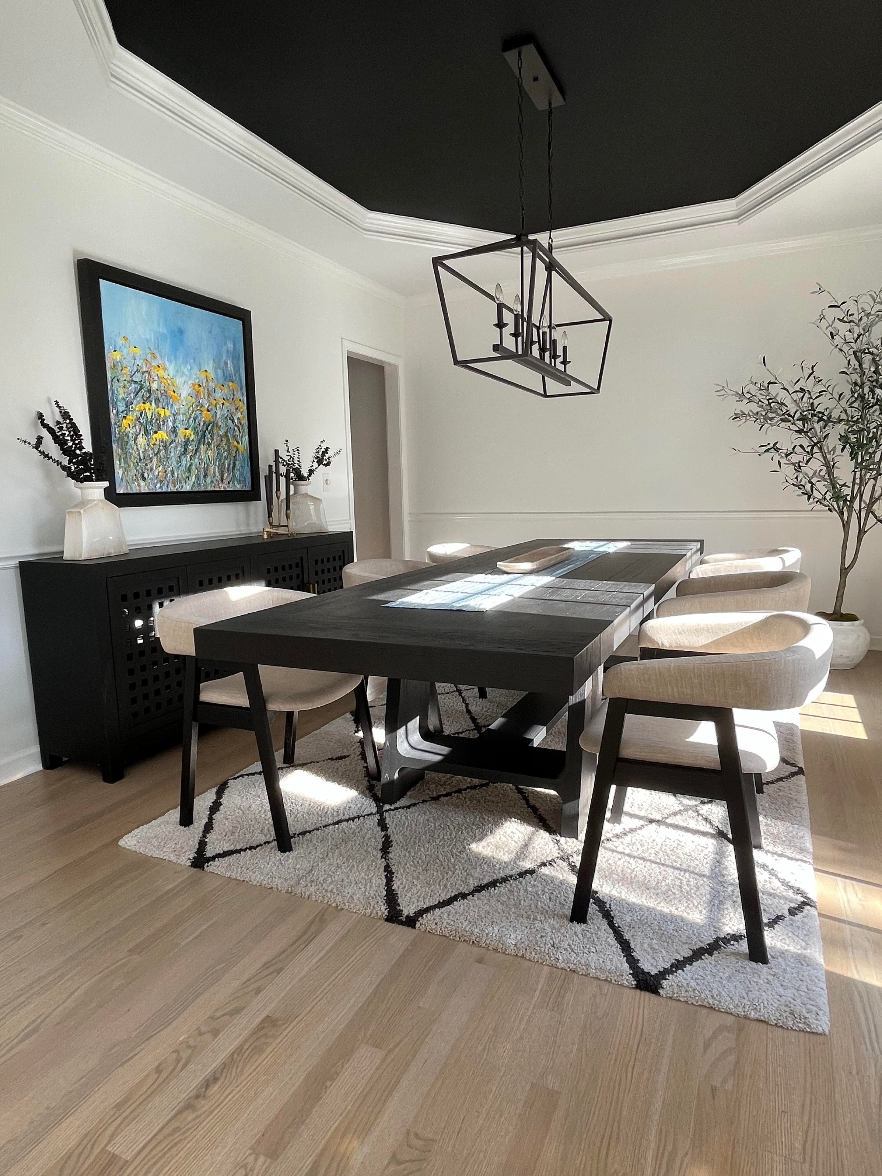 Charlotte dining room with dramatic black ceiling, crown molding, and light hardwood floors.