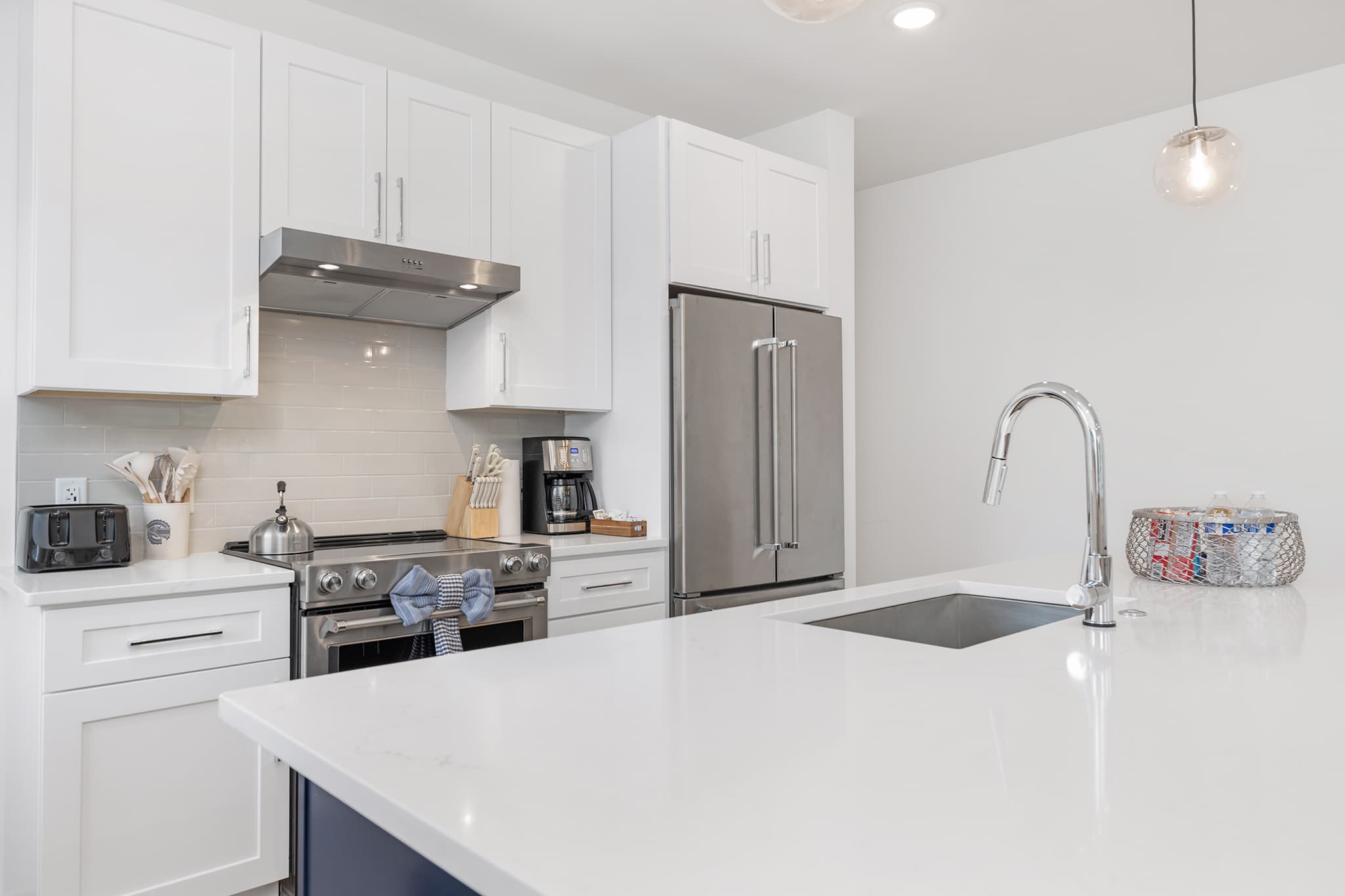 White shaker kitchen in Charlotte with tile backsplash and quartz counters.